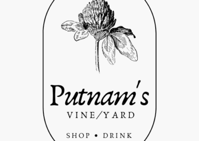 Putnam's Vineyard logo. a white background with a design of a clover flower over the words 'Putnam's Vineyard'